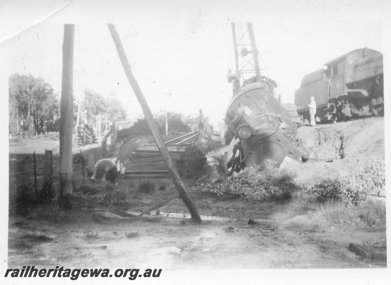 P14690
3 of 10, ES class 332  derailed on 10/6/1951, lying in a creek at Wooroloo, ER line, a PR class loco and a breakdown crane in the background,
