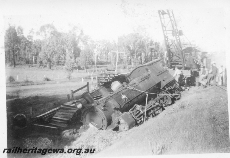 P14693
6 of 10, ES class 332 derailed on 10/6/1951, lying in a creek at Wooroloo, ER line, breakdown crane lifting the loco, 
