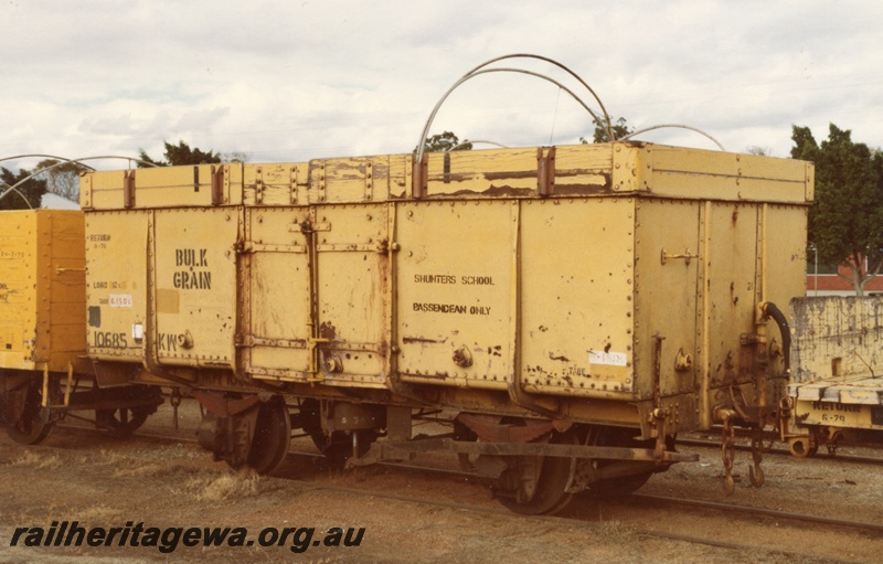 P14733
KW class 10685 steel open wagon with hungry boards and tarpaulin rails for wheat traffic, in yellow livery, side and end view, Bassendean, ER line.
