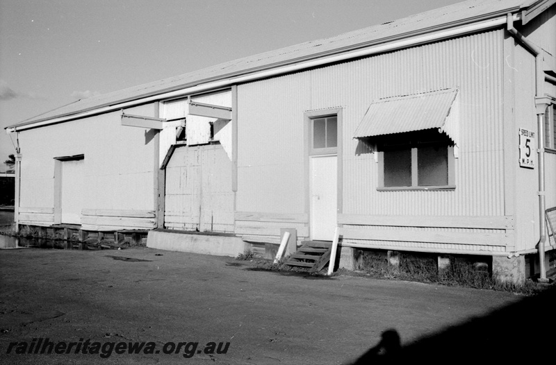 P14804
1 of 21 images of the railway precinct and station buildings at Subiaco, c1969, goods shed, streetside and partial end view, shows the girders of the crane  protruding from the side above the large door
