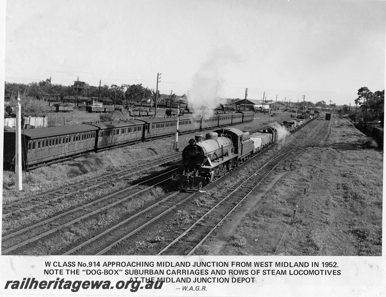 P14875
W class 914 steam locomotive on goods train, approaching Midland Junction from West Midland, dog-box carriages and rows of steam locomotives, coal dam gantry, semaphore signals and wagons in the background, ER line.
