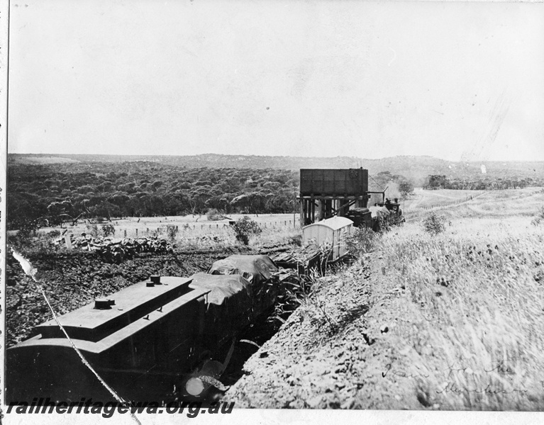 P14880
Steam locomotive on goods train taking on water at the water tower at Grants, NR line.
