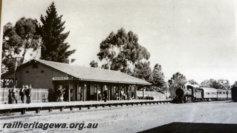 P14898
Station building, track side view with approaching passenger train, Harvey, SWR line, c1930s.

