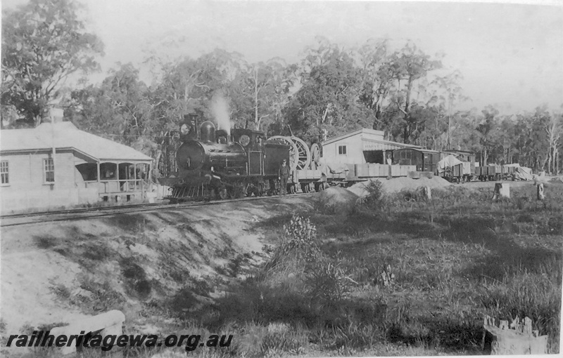 P14899
Station building, track side view, Post Office building next to the G class steam locomotive on a goods train, Harvey, SWR line.
