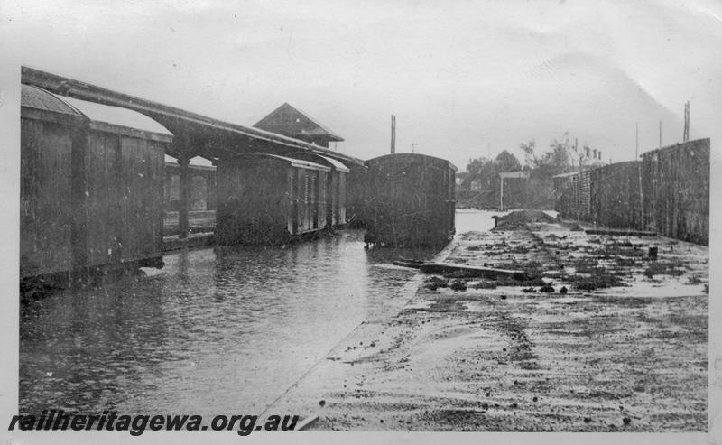 P14917
2 of 4 views of the floods at Kalgoorlie, EGR line, view shows water up to platform level, vans standing at the platform
