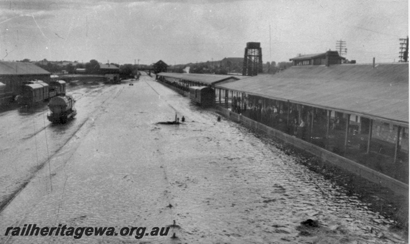 P14919
4 of 4 views of the floods at Kalgoorlie, EGR line, view looking east of the yard covered in water, water tower in the background
