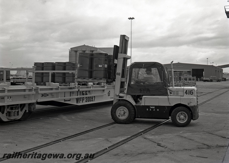 P15046
WFP class wagon 30097, being loaded by Fremantle Port Authority forklift 416 with drums of nickel matte, near FPA cargo terminal, North Quay, Fremantle Port, side view
