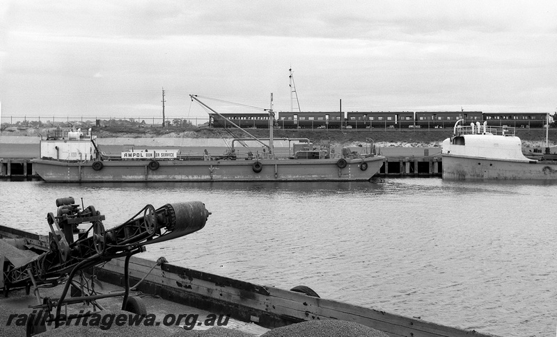 P15057
Rake of passenger carriages comprising 3 AJ class cars bookended by 2 AD class cars, side view, bracket signal, Ampol Bunker Service vessel and two others docked, Berth 10A, North Quay, Fremantle Port, c1959
