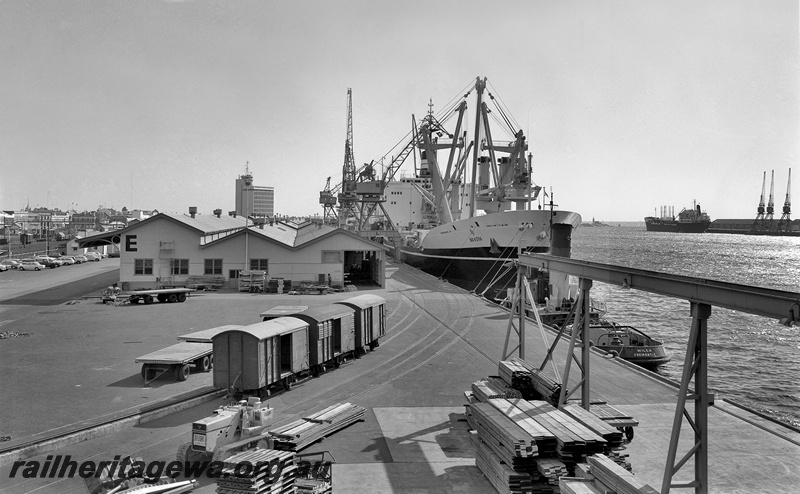 P15060
FD class 14292 and two other goods vans, standing in quayside sidings, tractor, pallets, timber, road trailers, E Shed, Fremantle Port Authority Building, ship Manora and tug Wilga docked, E Berth, Fremantle Port, c1967
