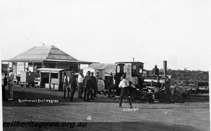 P15113
An unidentified steam locomotive, Roebourne's first, pictured outside a tailor shop. Note the flat wagon with a water tank as a load and the low level passenger vehicle adjacent.
