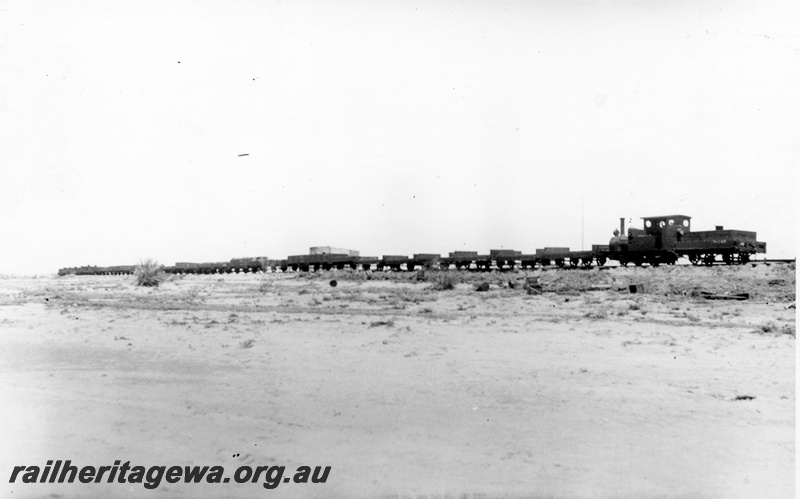 P15142
H class 22 steam locomotive with a rake of 4 wheeled wagons on the Port Hedland to Marble railway.PM line
