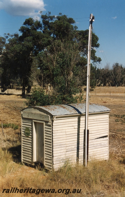 P15171
2 of 3 views of the round roof staff cabin at Isandra, PN line, elevated view of the front and side and the tall telegraph pole beside the shed.
