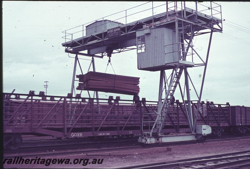 P15206
Overhead gantry crane, Parkeston, TAR line, unloading timber form WAGR wagons and being loaded onto Commonwealth Railways (CR) wagons
