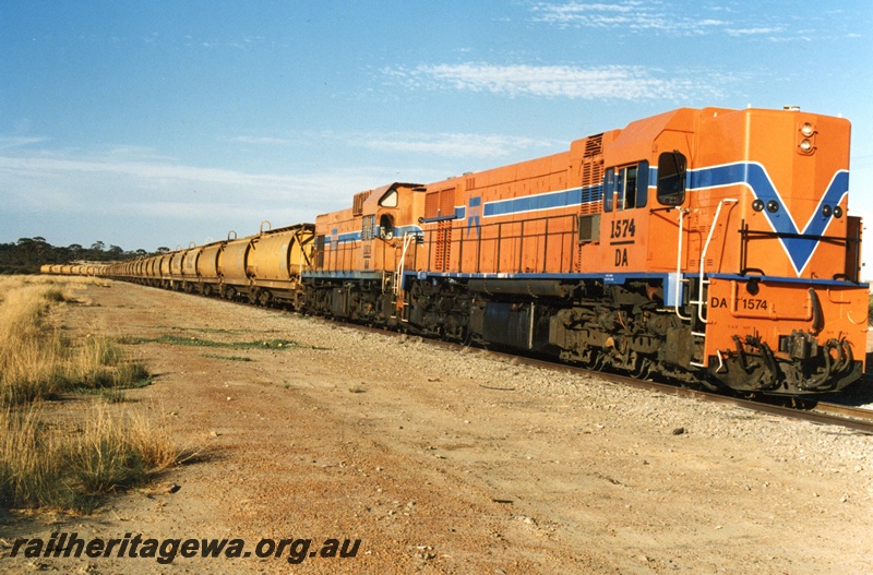 P15222
DA class 1574 and AA class 1519 diesel locomotives at the head of a wheat train at Amery GM line.
