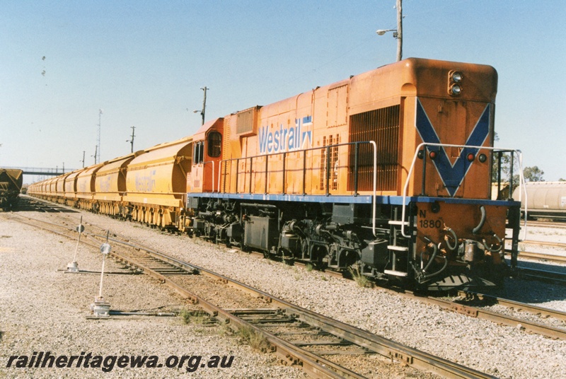 P15229
N Class 1880, on ilmenite train comprising XY wagons, Kwinana, little david points levers. The wagons were built for the new mineral sands plant at Chandala near Muchea and used to transport sand to Kwinana for processing.
