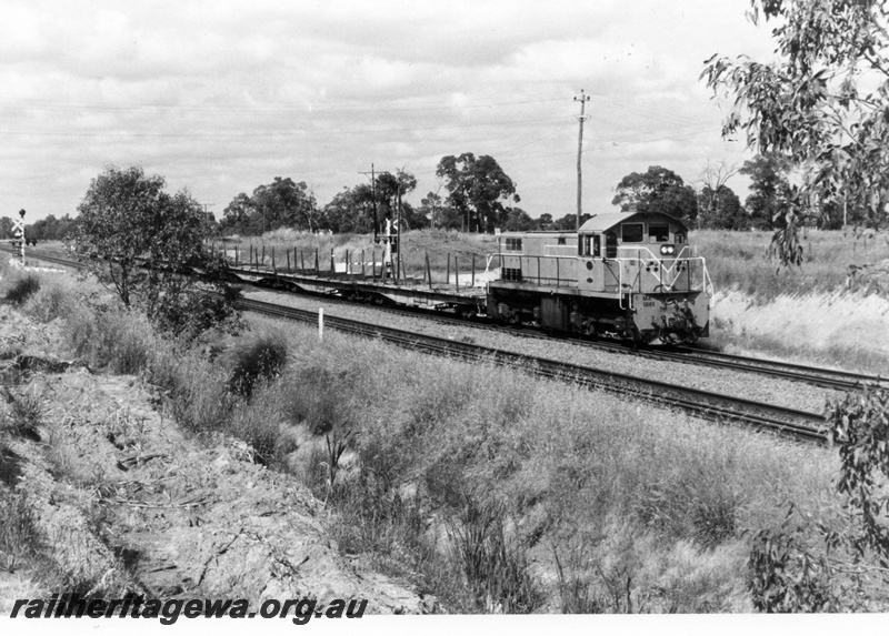 P15496
MA class 1861leads the Midland Shunter through Hazelmere at 9.45 am northwards towards Midland, train composed of QU class bogie flat wagons.
