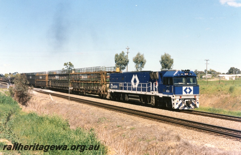 P15509
National Rail NR class 56 in the Seatrain blue livery heads a north bound freight through Hazelmere, empty three deck car carrying wagons behind the loco, view along the train.
