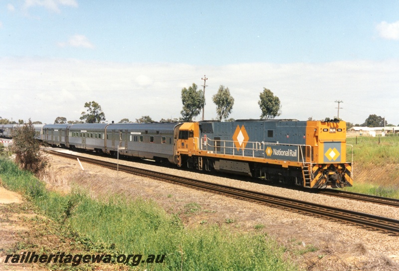 P15510
National Rail NR class 96 in the orange and grey livery, long hood leading, hauls an empty Indian Pacific through Hazelmere to the East Perth Terminal..
