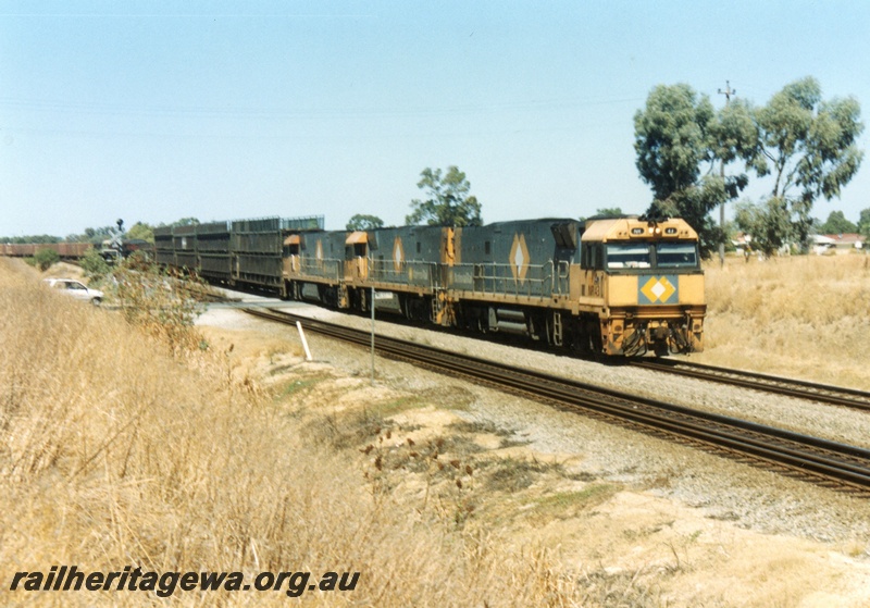 P15518
National Rail NR class 43 coupled to two other NR class loco, all in the orange and grey livery, head an interstate freight train northwards through Hazelmere, view along the train
