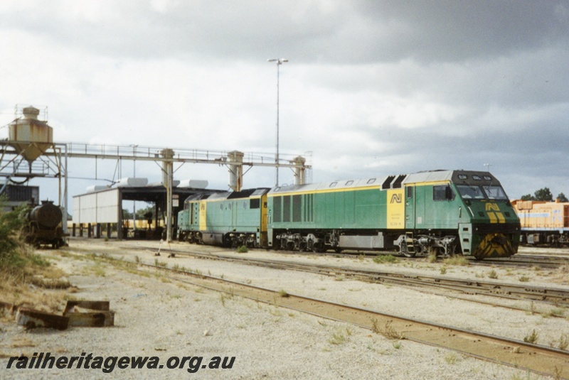 P15590
Australian National EL class 54 coupled to a DL class loco, in the green livery with yellow stripes on the nose and a yellow stripe and panel on the side, Forrestfield Yard, side and front view.

