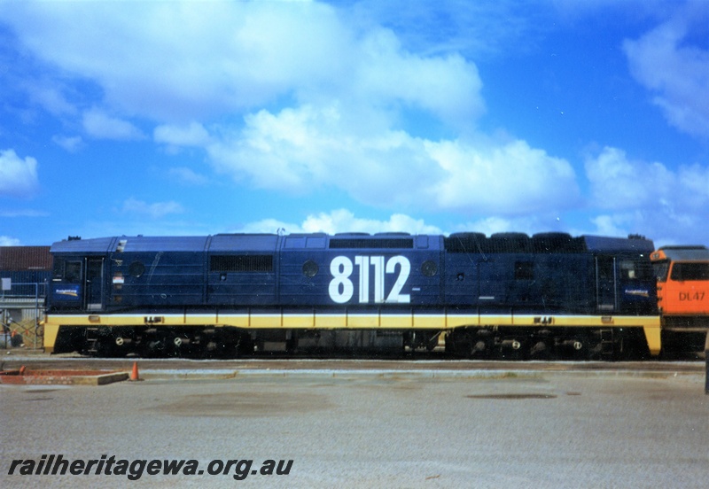 P15598
National Rail ex NSWR 81 class 8112 in the blue livery with yellow stripe along the side, Kewdale, side view
