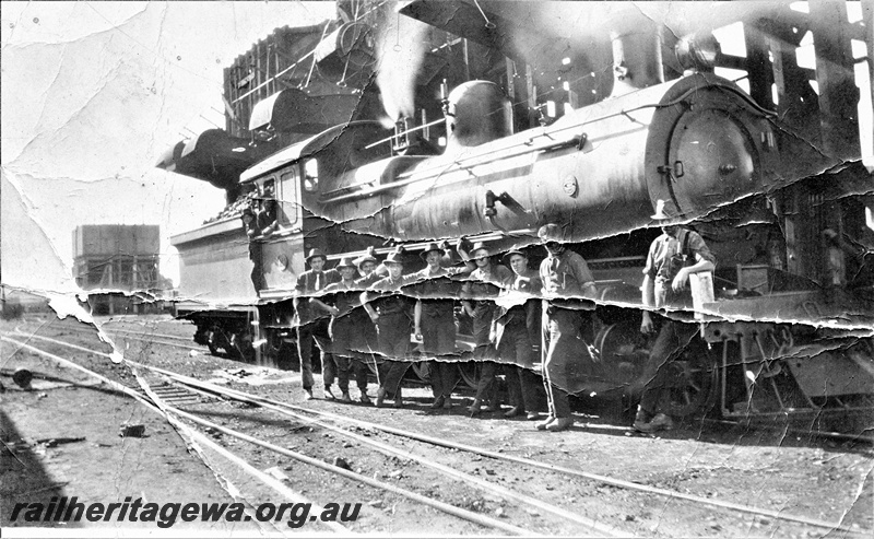 P15637
F class loco, water tower, elevated coal stage, group of workers posing along the side of the loco, Midland  Junction loco, depot, ER line, side and front view, photo damaged.
