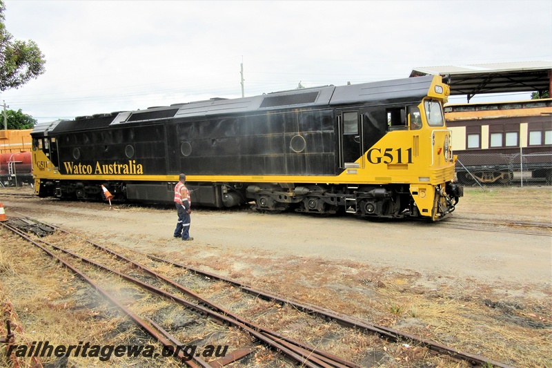 P15655
Watco Australia loco G class 511 in the yellow and black livery passing through the site of the Rail Transport Museum heading towards UGL's plant in Bassendean, side and leading end view
