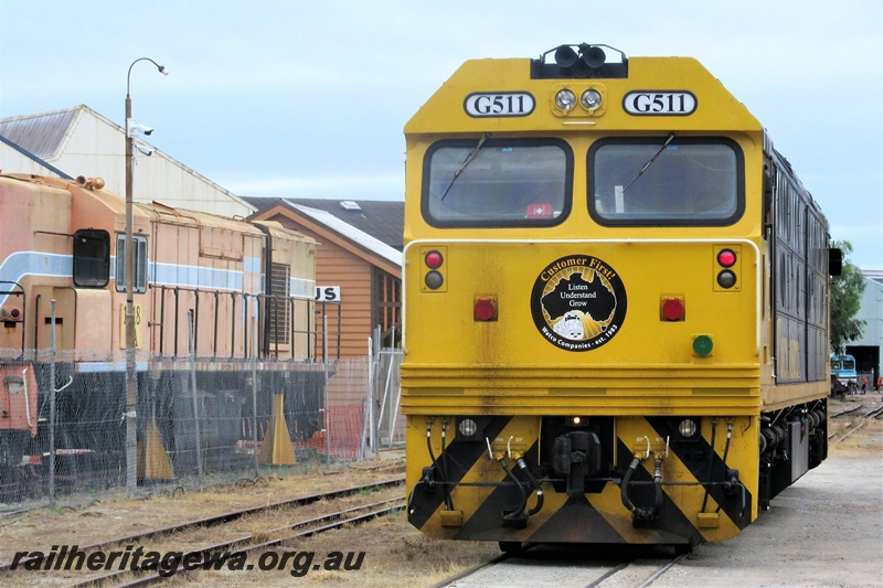 P15657
Watco Australia loco G class 511 in the yellow and black livery passing through the site of the Rail Transport Museum heading towards UGL's plant in Bassendean, mainly trailing end view
