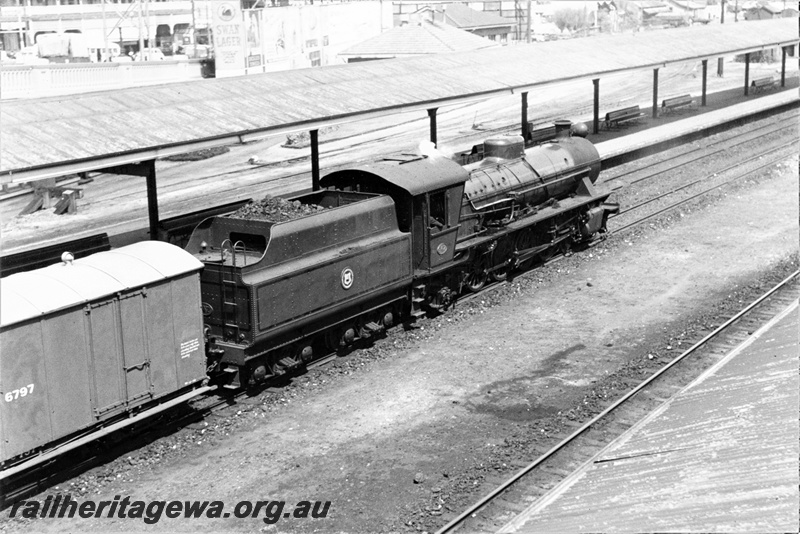 P15668
W class 947 in original condition with black lining on the cab and tender sides, WAGR insignia of the tender side and unmodified dome, Y class 6797 Powder van behind the loco, passing west bound through Perth station
