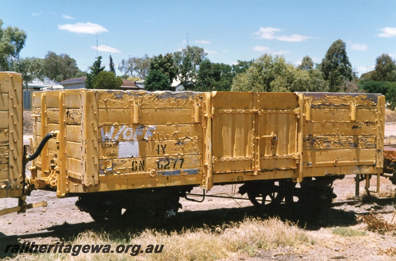 P15723
GN class 6277 four wheel medium sided wagon, yellow livery in poor condition, stowed at the old Northam station precinct, end and non brake lever side view
