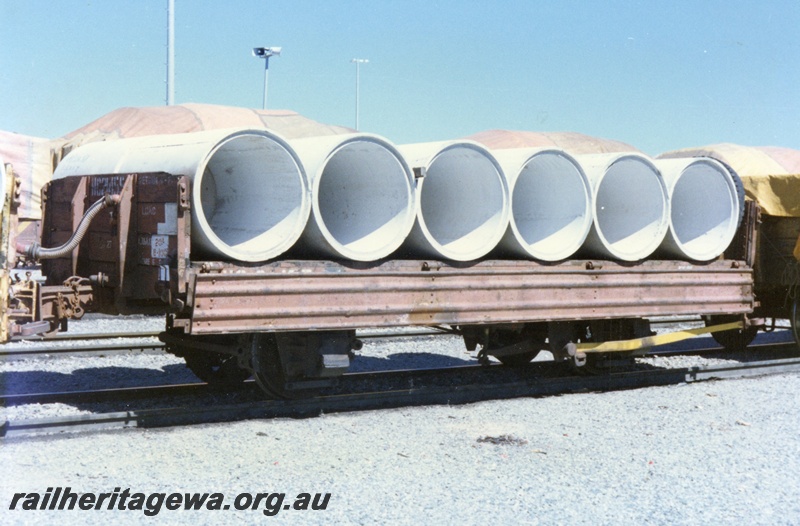 P15736
HC class 21455, four wheel low sided wagon with sides down and a load of concrete pipes, brown livery, Forrestfield Yard, end and brake lever side view
