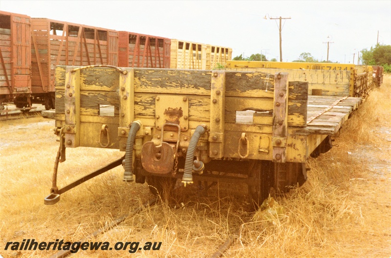 P15742
HDA class four wheel flat wagon with end bulkheads, yellow livery, BE class 20578 four wheel cattle wagon on the track behind, Bassendean 