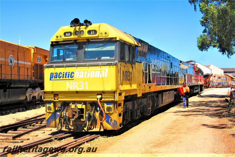 P15786
Pacific National NR class 31 passing through the site of the Rail Transport Museum having departed from UGL's site, Bassendean, leading MRL class 003. front and side view.
