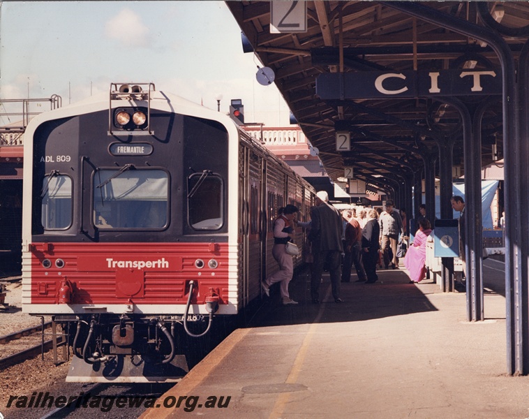 P15837
ADL class 809 in the short lived Transperth red and black livery, platform 2, Perth Station, front and side view, passengers disembarking
