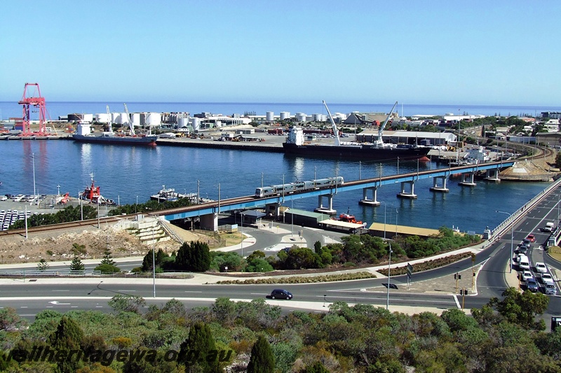 P15864
Two care EMU set on the Fremantle Rail Bridge, 12 Berth, North Wharf, Fremantle Harbour in the background, elevated view across the harbour
