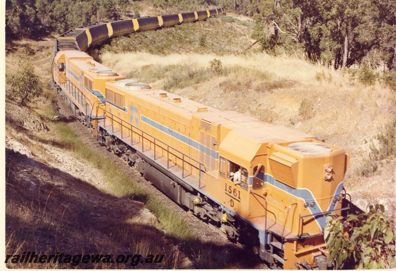 P15885
D class 1561 and another diesel loco, in Westrail orange with blue and white stripe livery, double heading a wood chip train, rural setting, front and side view taken from above 
