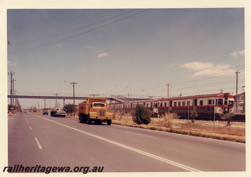 P15888
Suburban DMU, in red white and green colour scheme, overhead pedestrian footbridge, traffic on Guildford Road, train at Ashfield station, ER line
