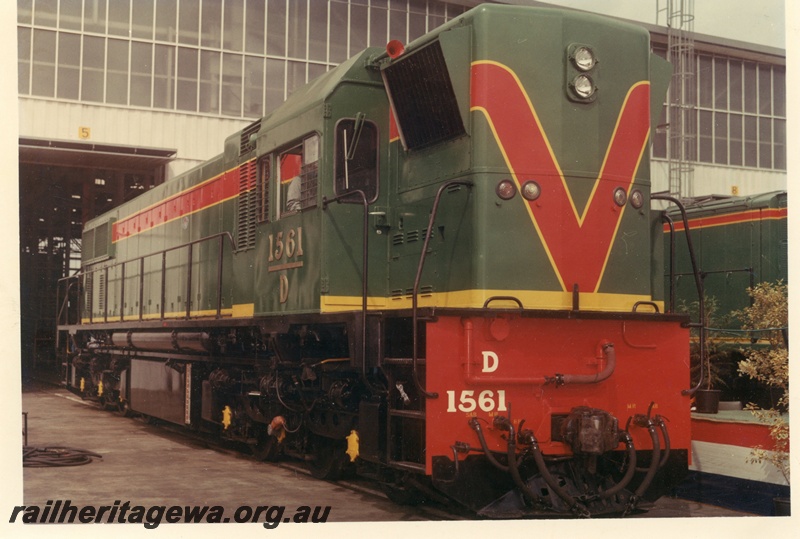 P15891
D class 1561, in green with red and yellow stripe livery, standing outside shed, side and front view
