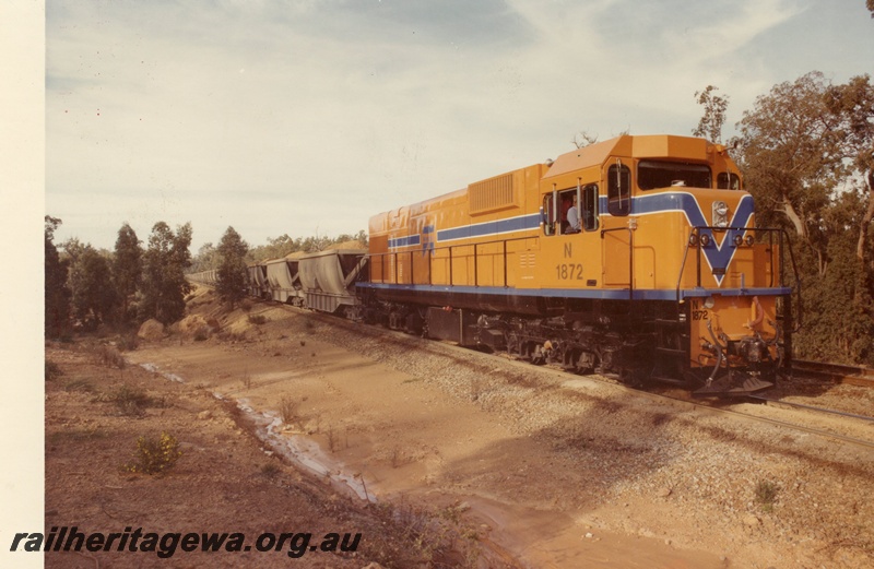 P15898
N class 1872, in Westrail orange with blue and white stripe, on bauxite train, trackside drain, rural setting, side and front view
