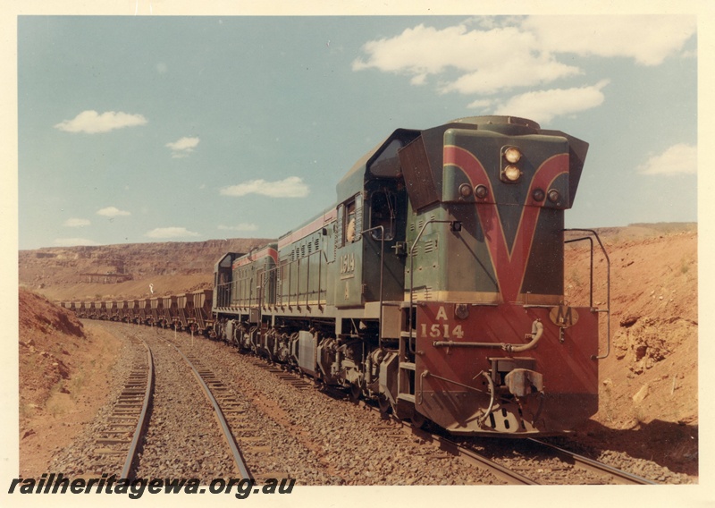 P15929
A class 1514, and another diesel loco, in green with red and yellow stripe, double heading iron ore train, Koolanooka Hills, EM line
