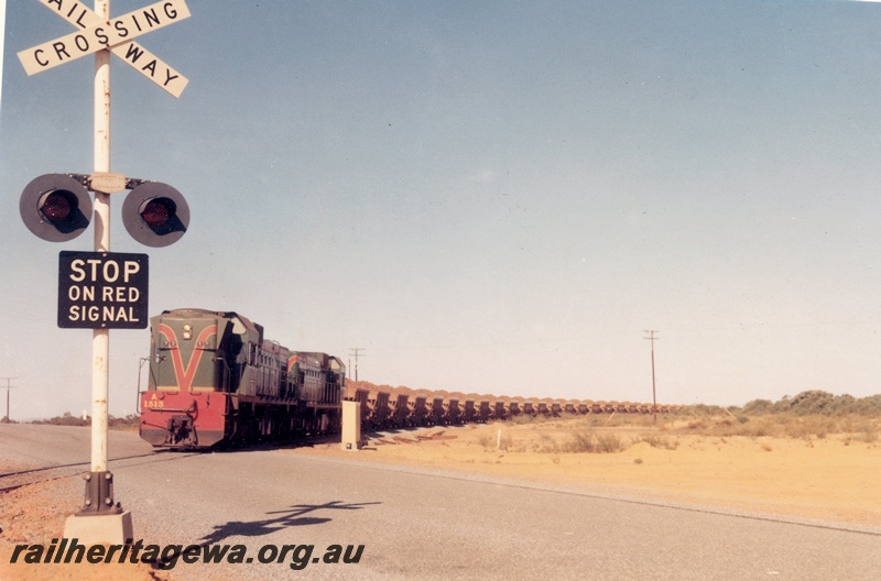 P15935
A class 1513, with another diesel loco, both in green with red and yellow livery, double heading iron ore train, level crossing, rural setting, front and side view
