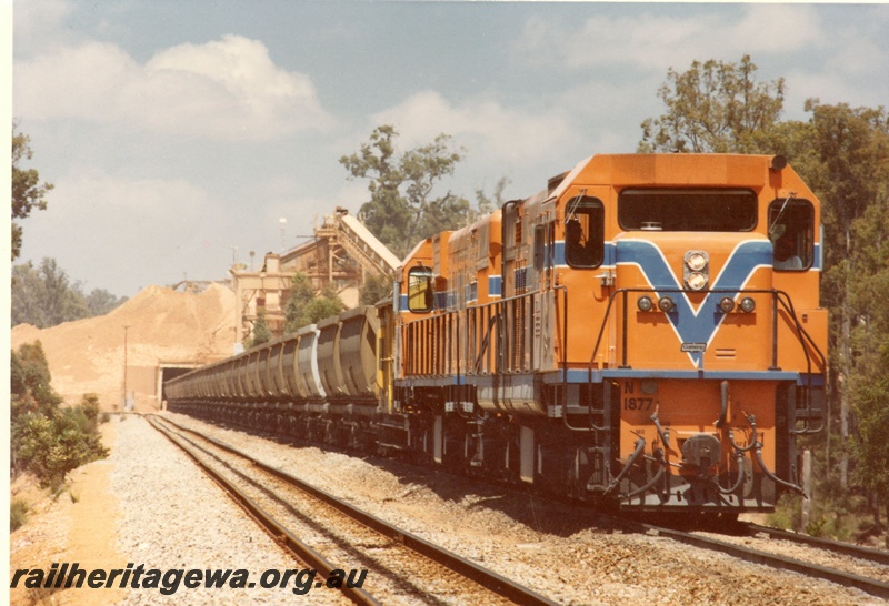 P15940
N class 1877 and another diesel loco, in Westrail orange with blue and white stripe, on bauxite train loading, bauxite loader, side and front view

