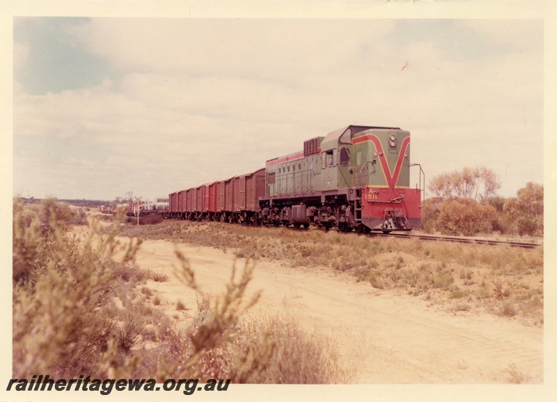 P15944
A class 1511, in green with red and yellow stripe, on goods train, rural setting, side and front view
