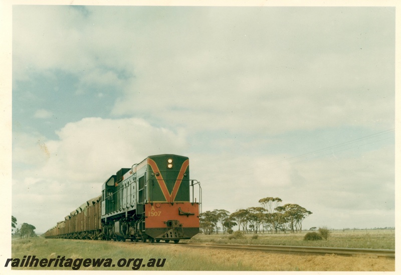 P15947
A class 1507, in green with red and yellow stripe, on wheat train, rural setting, side and front view
