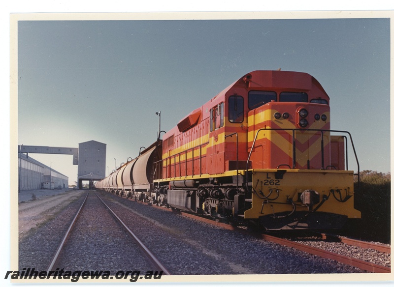 P15962
L class 262, in International safety orange, on grain train, loading, side and front view
