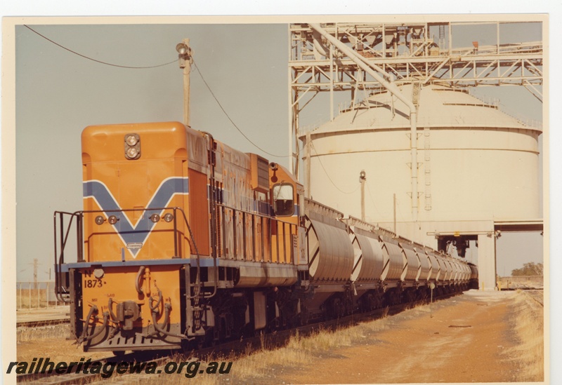 P15964
N class 1873, in Westrail orange with blue and white stripe, on alumina train of XF class wagons being loaded from above, loader, front and side view
