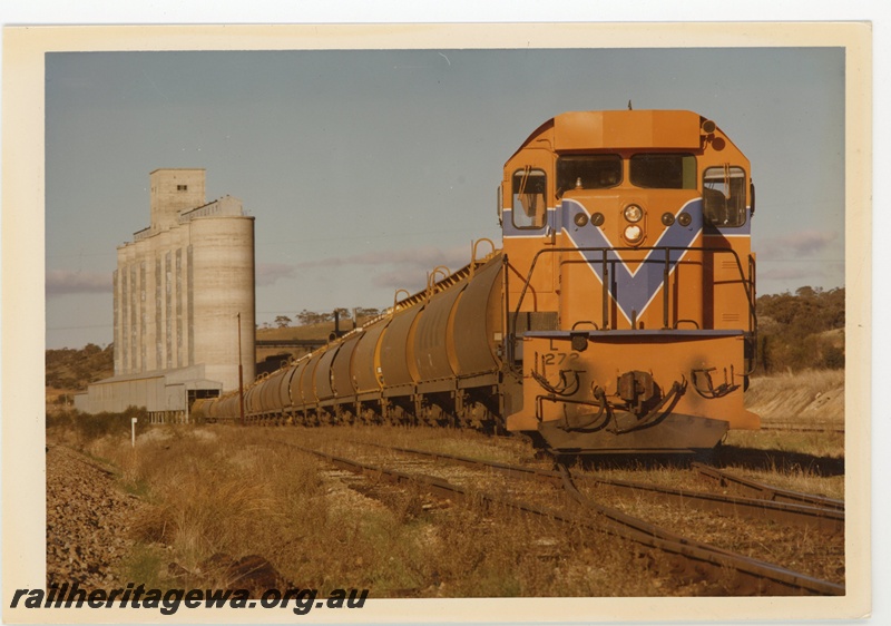 P15974
L class loco, on grain train, wheat silos, side and front view
