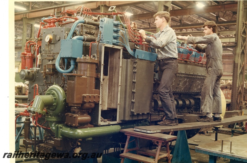 P15983
X /XA class engine Diesel engine, being worked on by two workers, Diesel Shop, Midland Workshops, close up view 
