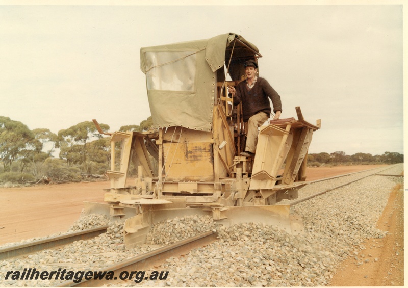 P16007
Mechanical ballast plough, in operation, with operator, canvas shelter, front and side view from track level
