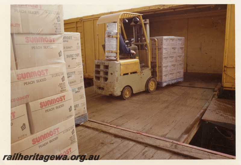 P16058
 1 of 2. Loading pallets of cartons of canned peaches into a VH class covered van at Manjimup.

